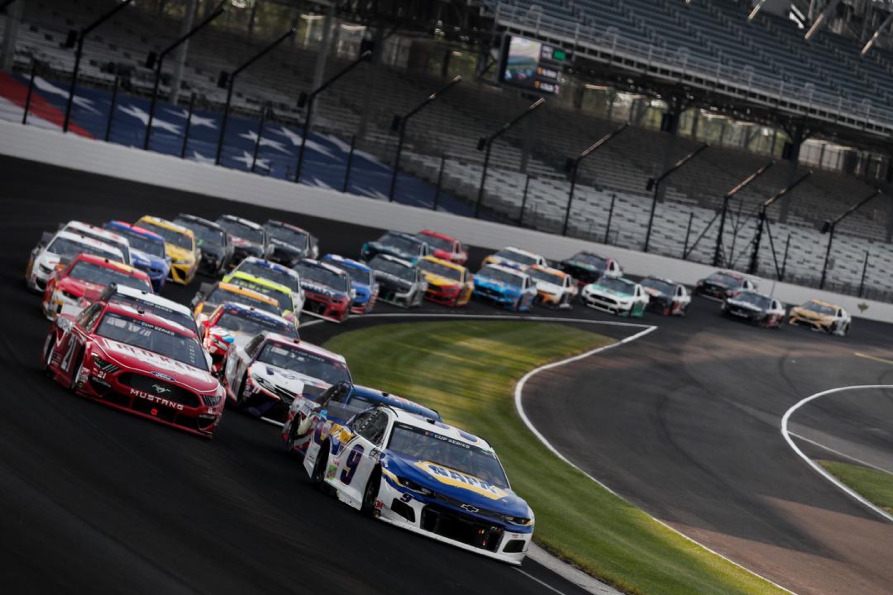 Chase Elliott leads the NASCAR Cup Series field through Turn 1 at Indianapolis Motor Speedway